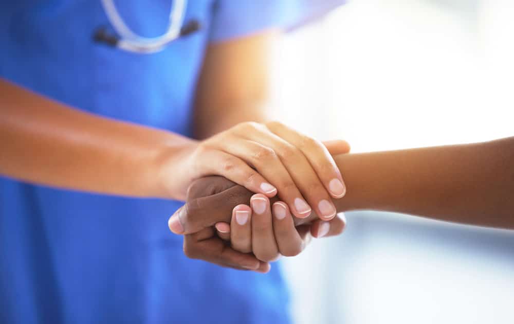 nurse and patient holding hands
